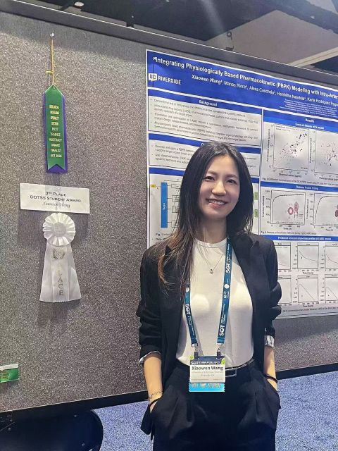 Xiaowen Wang beside her PBPK research poster and award ribbons.